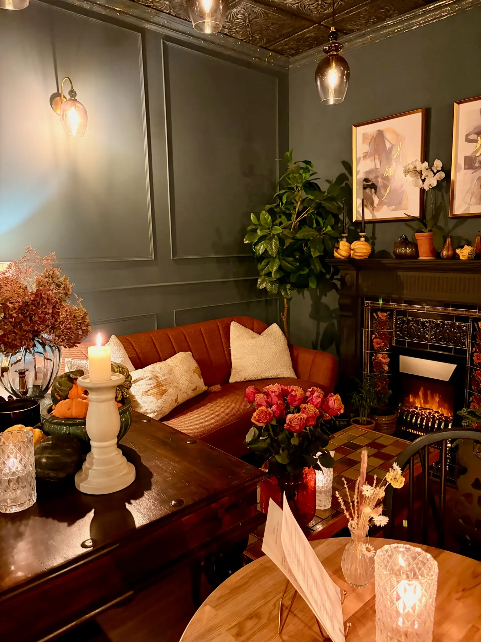 Candlelit lounge with velvet sofa, fireplace and roses