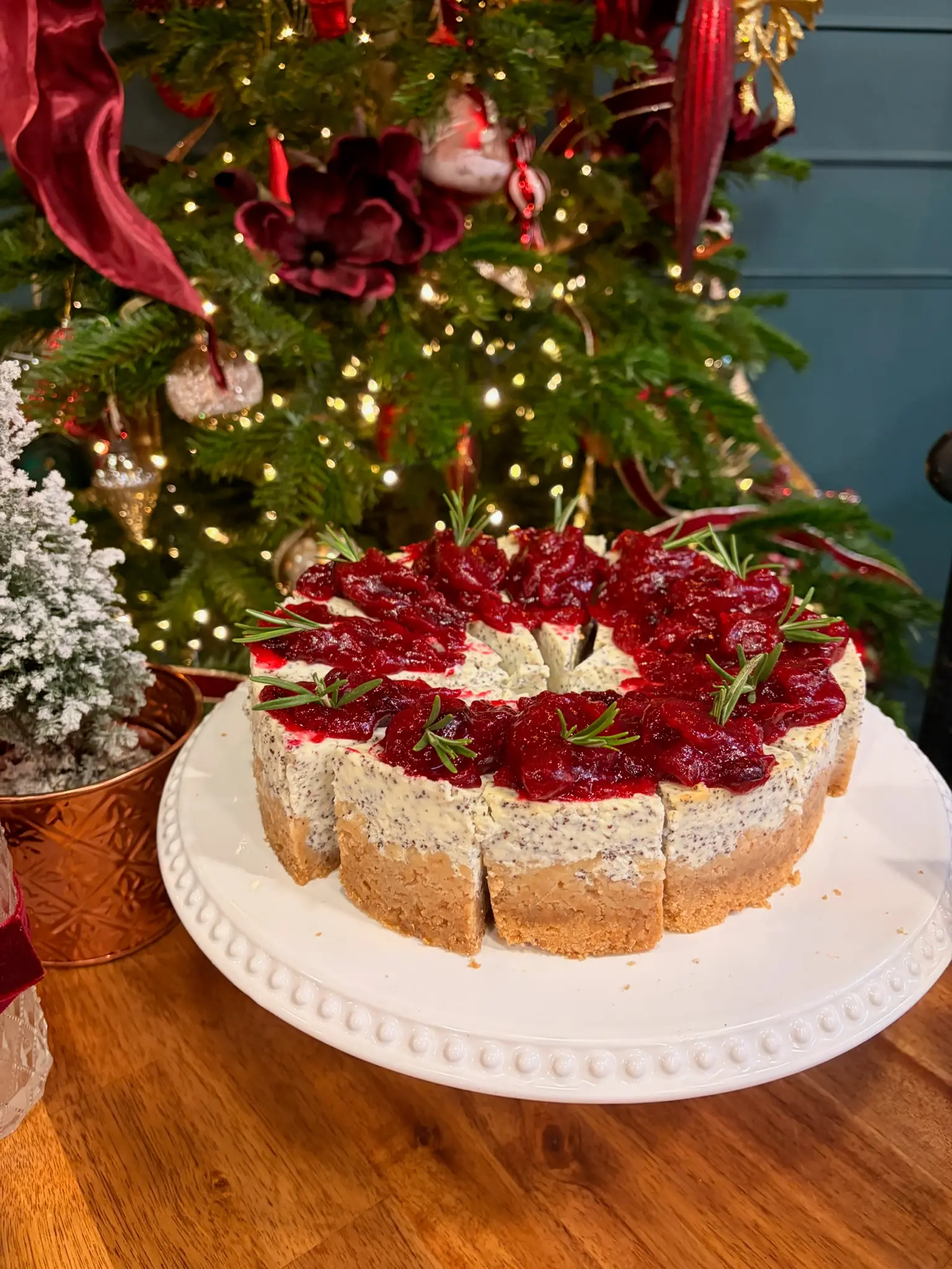 Cranberry cheesecake with rosemary garnish by Christmas tree