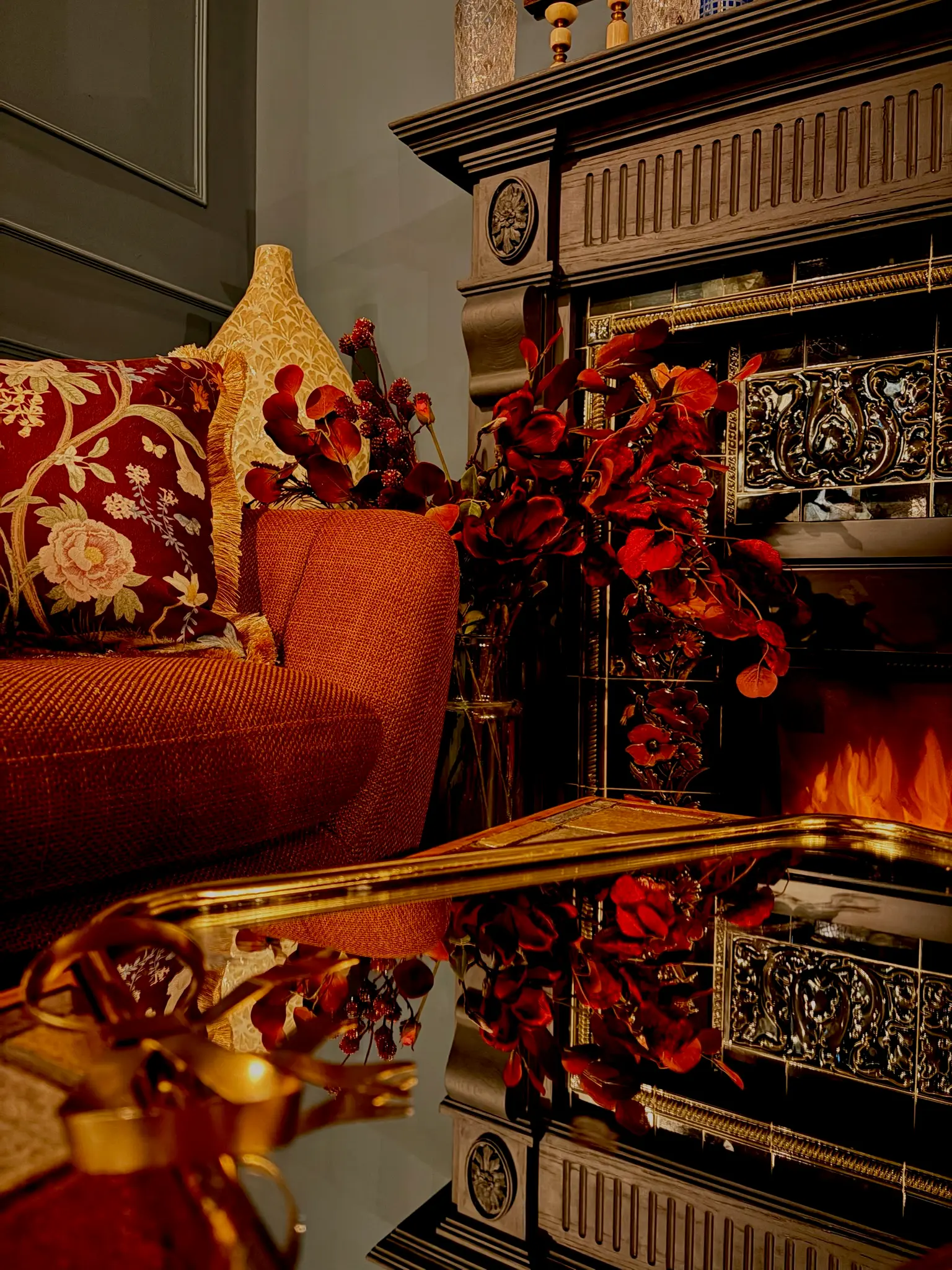 Ornate fireplace with red roses and warm candlelight