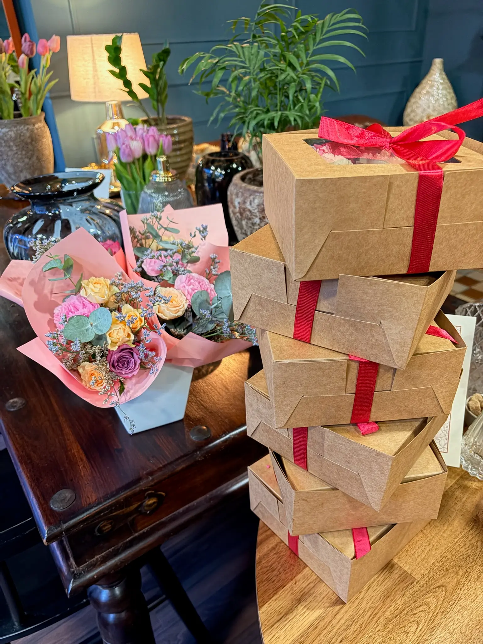 Stacked Valentine's gift boxes with ribbon and flower bouquet