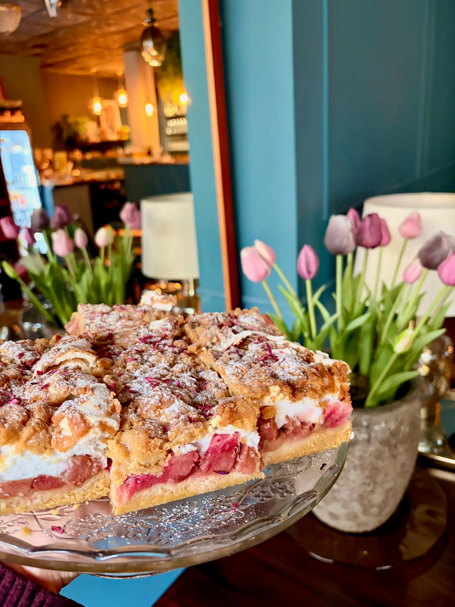 Strawberry crumble traybake with spring tulips in the background
