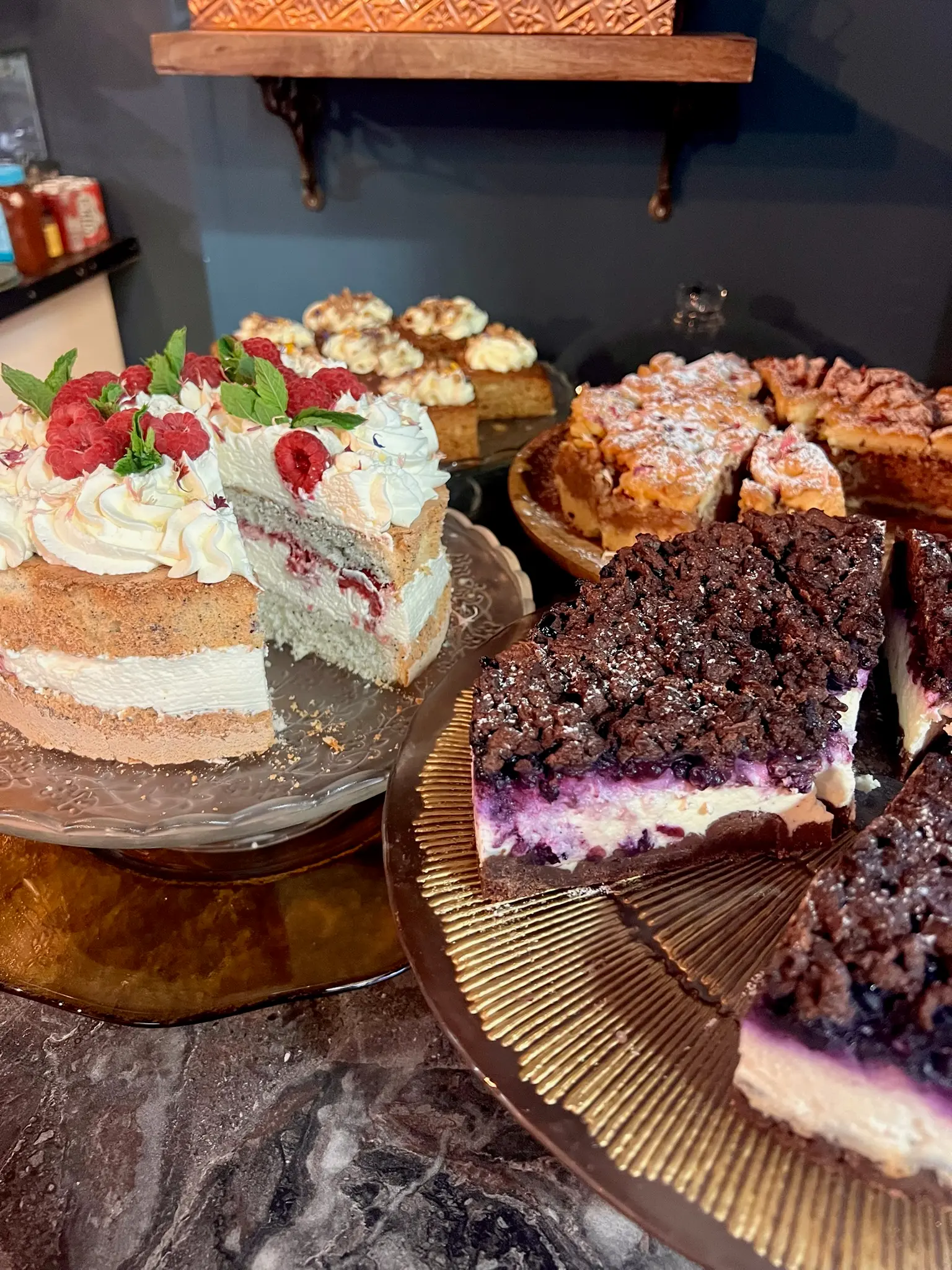 Cake counter display with raspberry layer cake and baked goods
