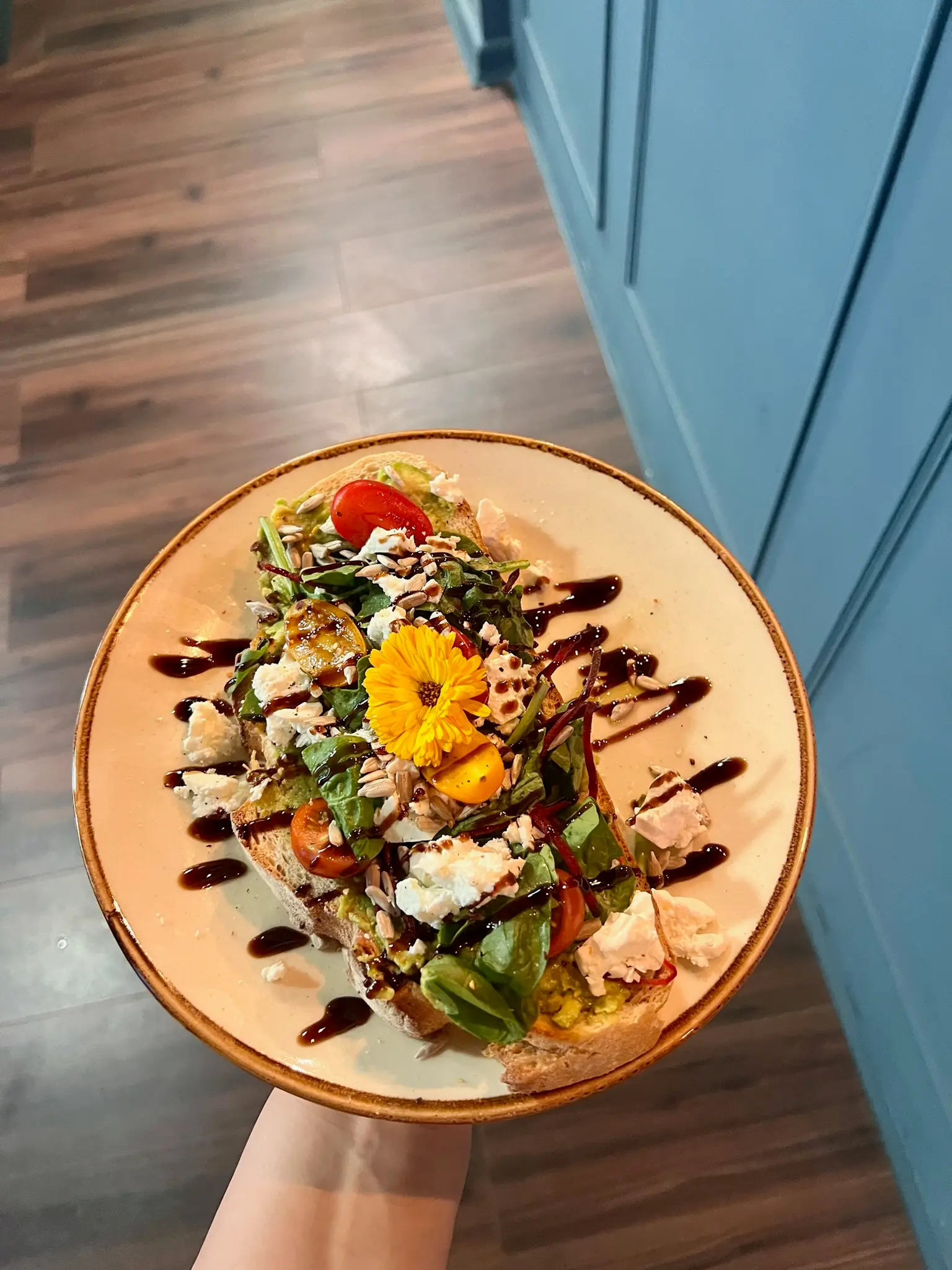 Avocado toast with feta, edible flower and balsamic drizzle