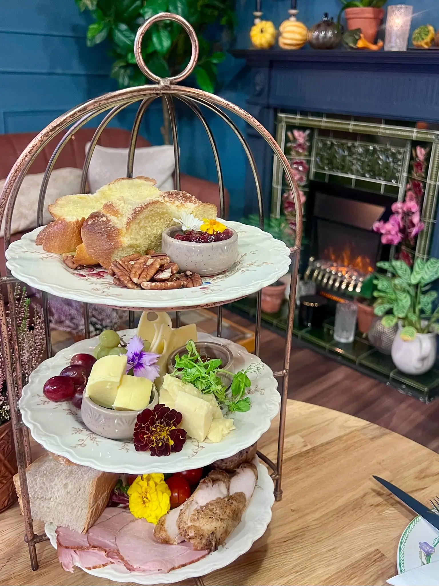 Three-tier afternoon tea stand with sandwiches, cheese and charcuterie
